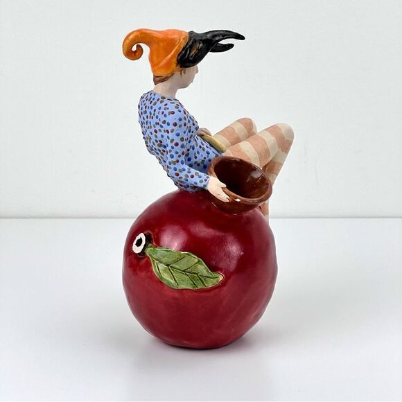 CARRIANNE L HENDRICKSON woman with beak hat sitting on apple sculpture 2… - Picture 6 of 16